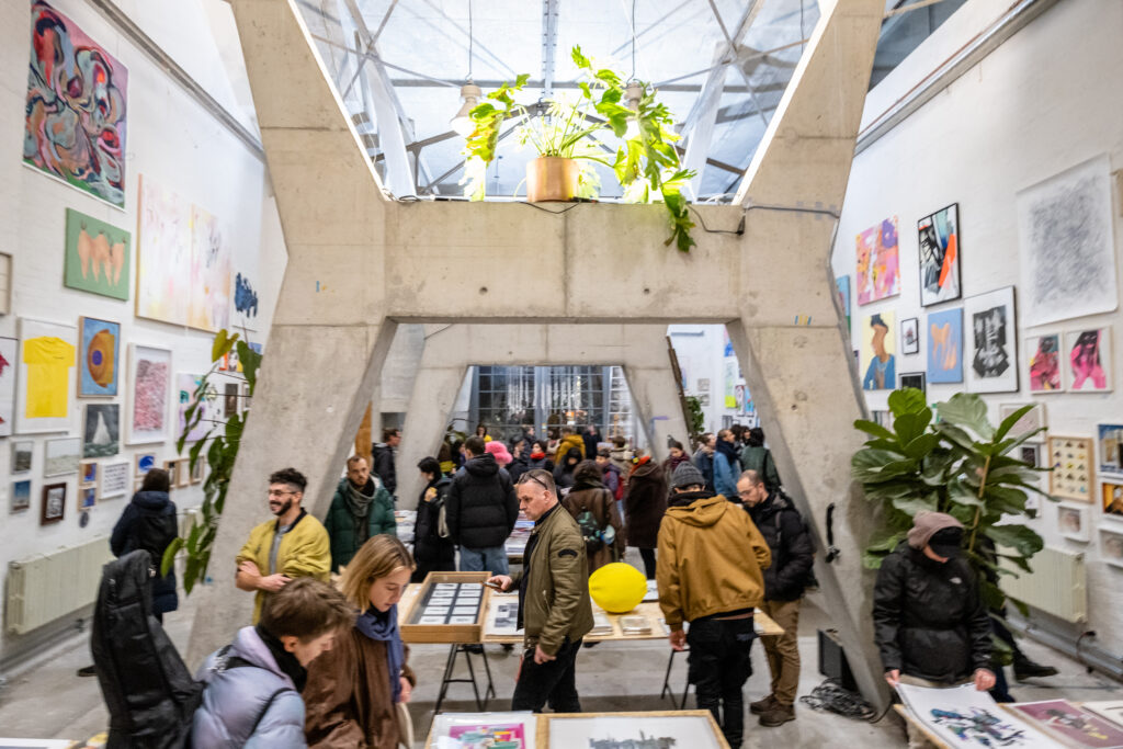 picture of art market with pictures hanging on walls and on tables